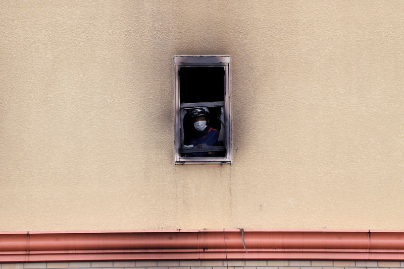 © Reuters. A firefighter looks out of a window at the torched Kyoto Animation building in Kyoto