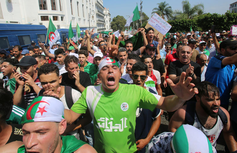 © Reuters. Demonstrators chant slogans during a protest demanding the removal of the ruling elite in Algiers