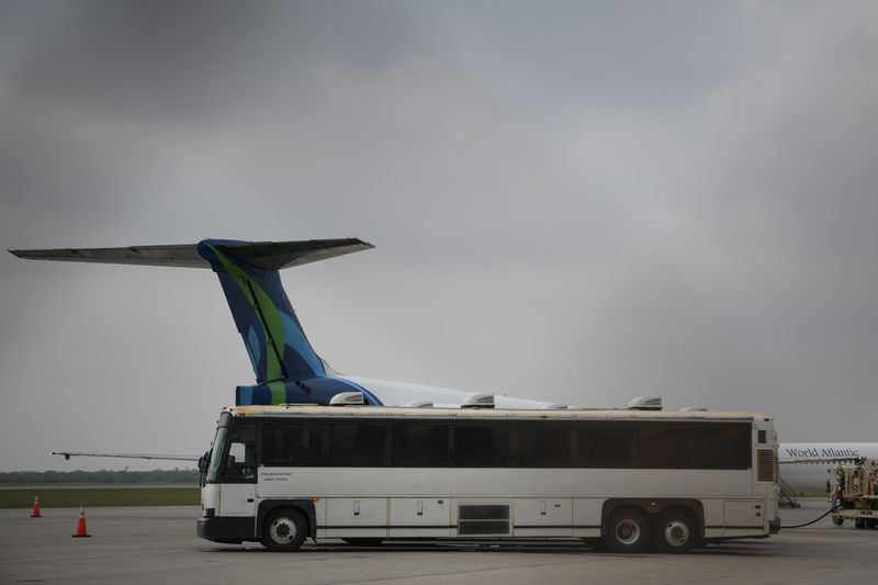 © Reuters. FILE PHOTO -  Transport buses used to carry migrants in U.S. Immigration and Customs Enforcement (ICE) custody are seen parked next to chartered planes before departure from Brownsville South Padre International Airport in Brownsville