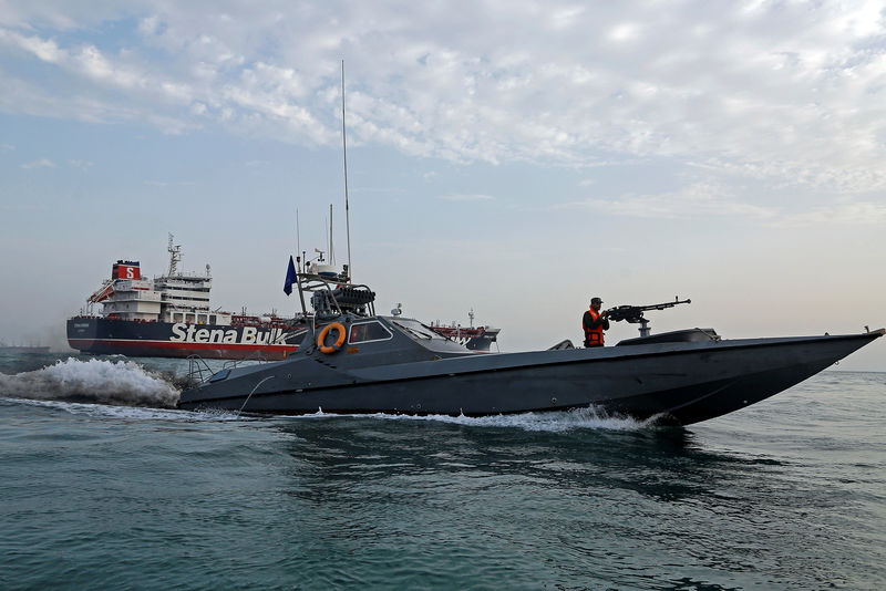 © Reuters. A boat of the Iranian Revolutionary Guard sails next to Stena Impero at Bandar Abbas port