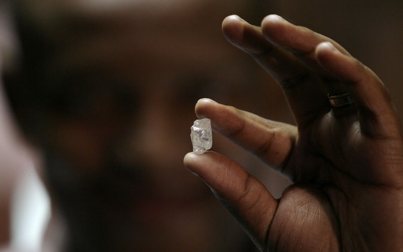 © Reuters. A visitor holds a 17 carat diamond at a Petra Diamonds mine in Cullinan