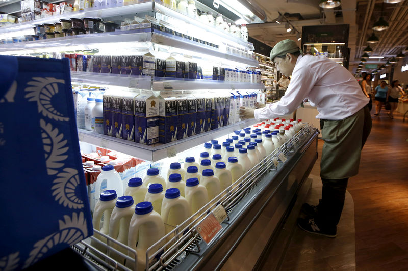 © Reuters. FILE PHOTO: A salesman arranges milk products imported from Australia at a supermarket inside IAPM mall in Shanghai