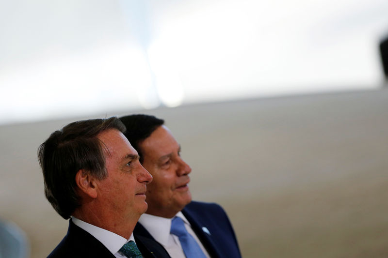 © Reuters. Brazil's President Jair Bolsonaro stands near Brazil's Vice President Hamilton Mourao as they arrive to a ceremony to launch the new worker fund stimulus at the Planalto Palace in Brasilia