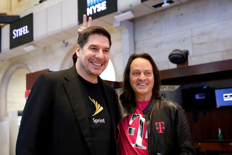 © Reuters. FILE PHOTO: T-Mobile CEO John Legere and Sprint CEO Marcelo Claure pose for pictures on the floor of the New York Stock Exchange in New York