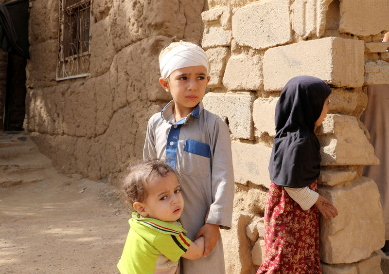 © Reuters. FILE PHOTO: Air strike survivor Mukhtar Hadi stands with family in Saada