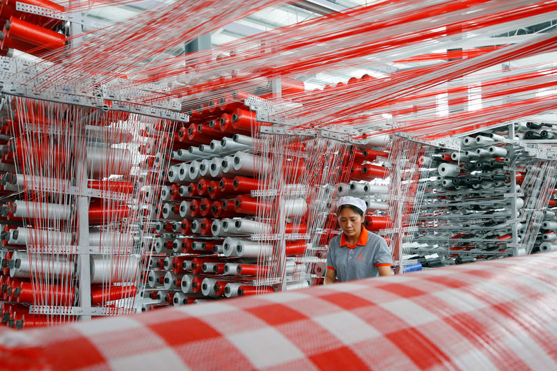 © Reuters. Woman works at a workshop manufacturing plastic woven materials for packaging products in Suqian, Jiangsu