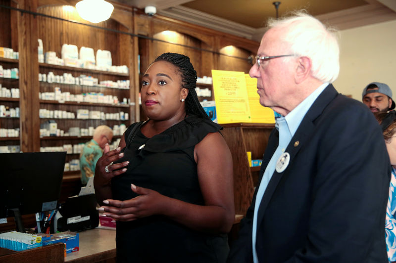 © Reuters. U.S. citizen Jillian Rippolone, who lives with type 1 diabetes, talks to U.S. Sen. Bernie Sanders about the high cost of U.S. health care inside the Canadian pharmacy in Windsor, Ontario