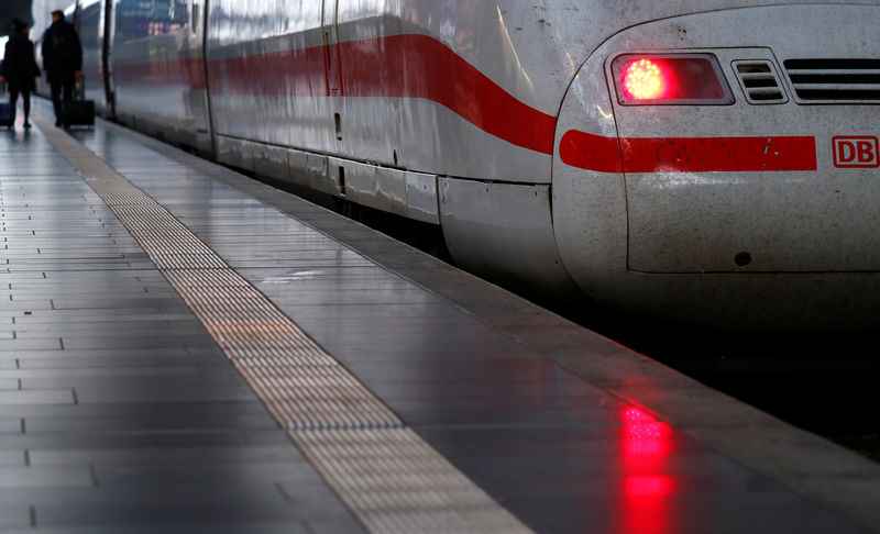 © Reuters. Passengers walk past a high speed ICE train of German railway Deutsche Bahn at the main train station in Frankfurt
