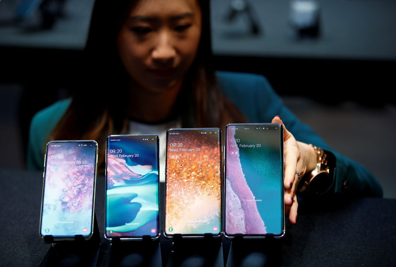 © Reuters. FILE PHOTO: A Samsung employee arranges the new Samsung Galaxy S10e, S10, S10+ and the Samsung Galaxy S10 5G smartphones at a press event in London