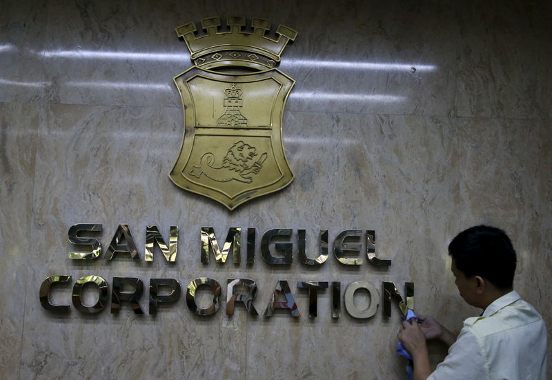 © Reuters. FILE PHOTO: A worker cleans a logo of San Miguel Corporation (SMC) inside a main office in Mandaluyong city, metro Manila