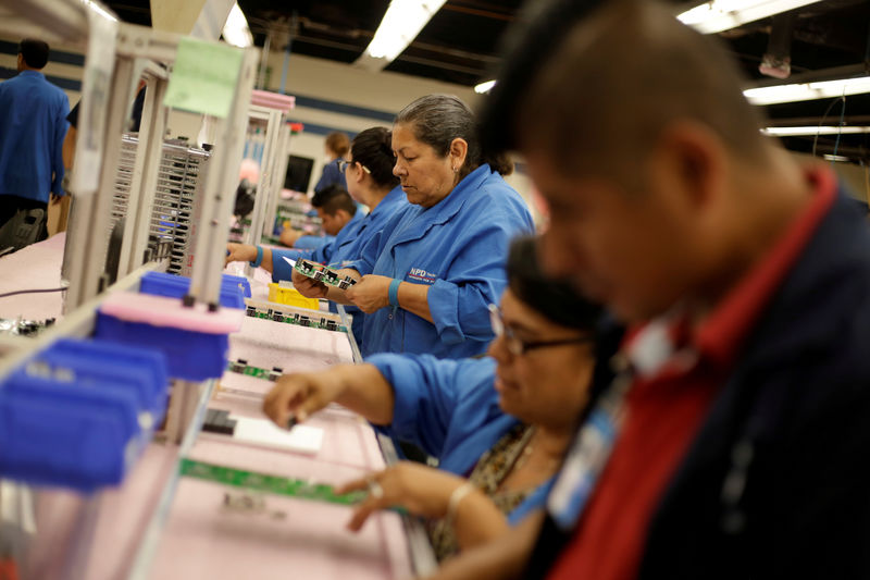 © Reuters. FILE PHOTO: Employees of NDP Technology, a private company specialised in PCB (Printed Circuit Board) assembly for different industries, works on a printed circuit board in Ciudad Juarez