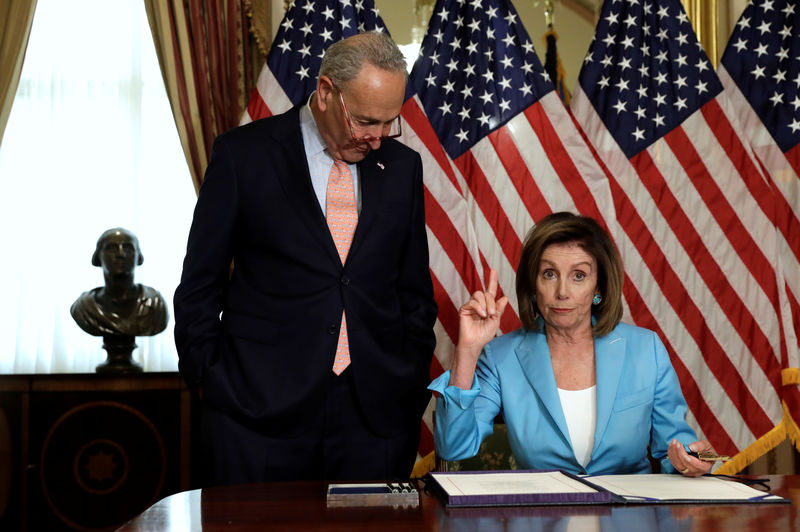 © Reuters. House Speaker Nancy Pelosi with Chuck Schumer signs the Bipartisan Budget Act of 2019