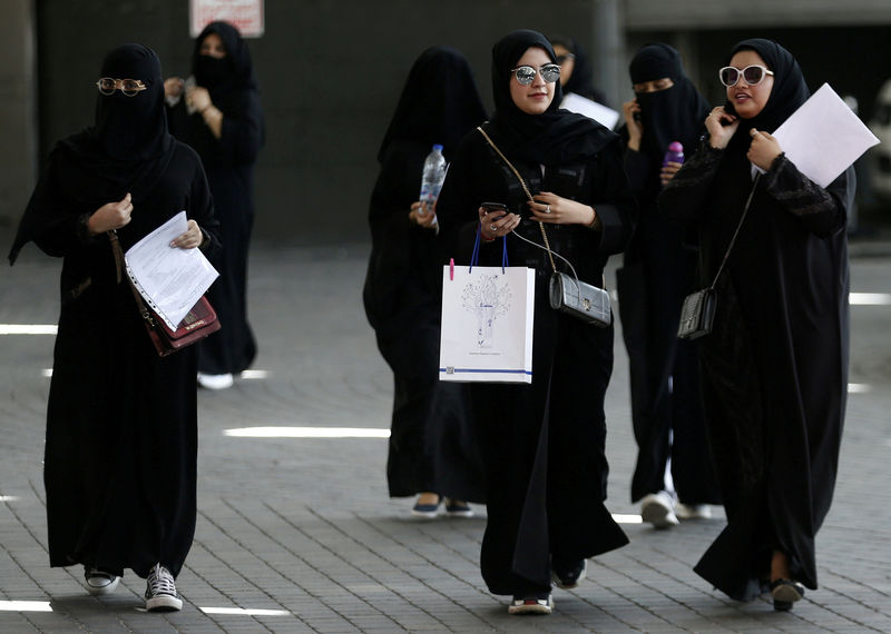 © Reuters. FILE PHOTO: Saudi students walk at the exhibition to guide job seekers at Glowork Women's Career Fair in Riyadh