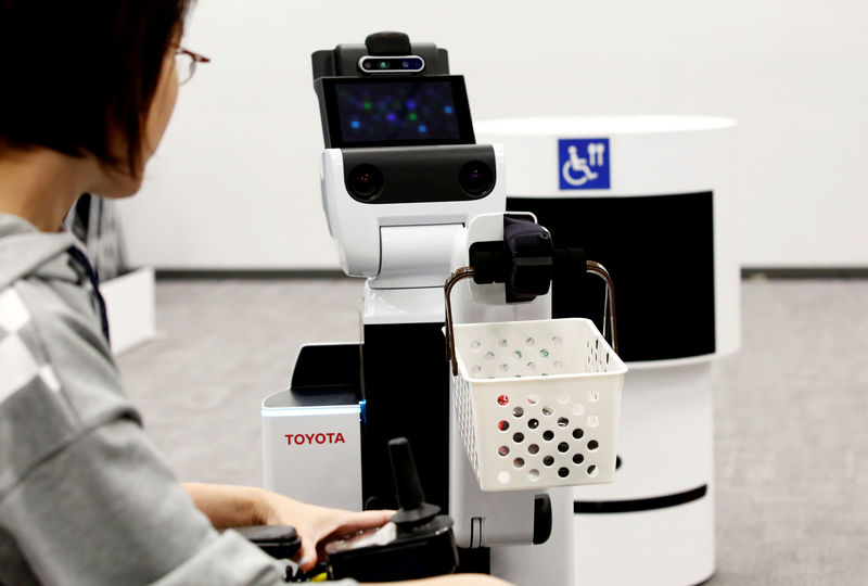 © Reuters. FILE PHOTO: Toyota's HSR (Human Support Robot) delivers a basket to a woman in a wheelchair at a demonstration of Tokyo 2020 Robot Project for Tokyo 2020 Olympic Games in Tokyo