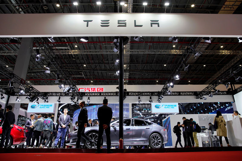 © Reuters. People visit a Tesla booth during the media day for the Shanghai auto show in Shanghai