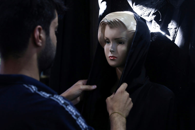 © Reuters. An Iraqi shop owner arranges abaya on a mannequin in the holy city of Kerbala