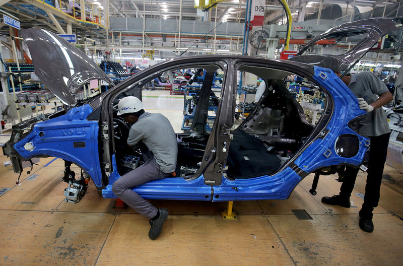 © Reuters. FILE PHOTO: Workers on a car assembly line at the Tata Motors plant in Sanand, on the outskirts of Ahmedabad