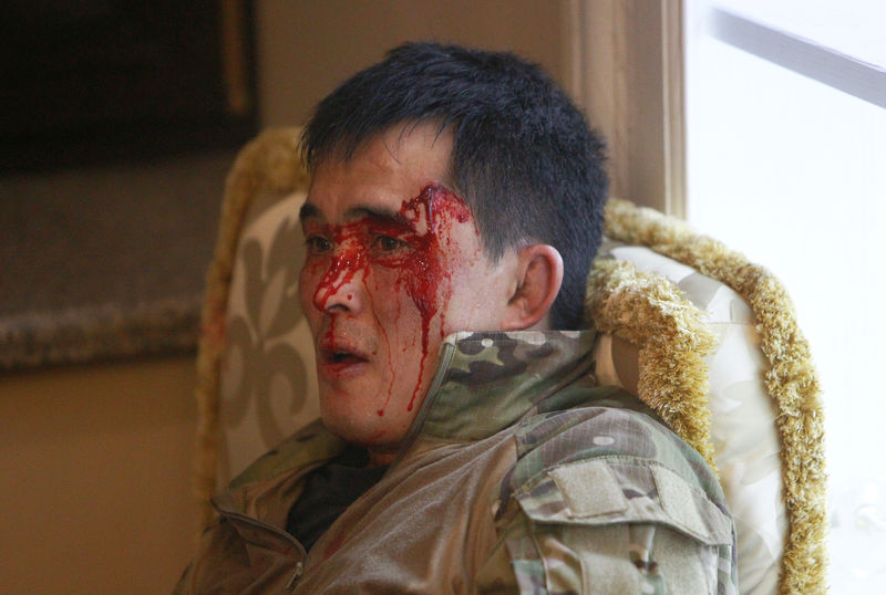 © Reuters. An injured member of Kyrgyz state security forces lies on the floor during an operation to detain former President Atambayev near Bishkek