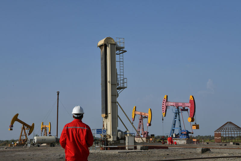 © Reuters. Workers are seen near pumpjacks at a CNPC oil field in Bayingol