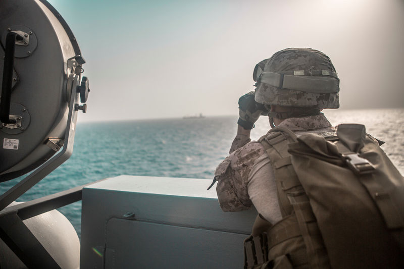 © Reuters. U.S. Marine Corps Cpl. Michael Weeks, ranges nearby boats from USS John P. Murtha during a Strait of Hormuz transit, Arabian Sea off Oman