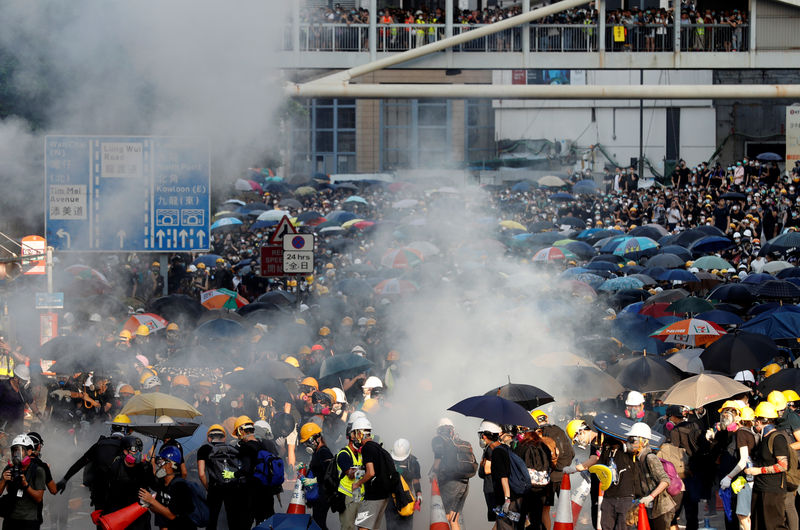 © Reuters. FILE PHOTO - Protesters react after tear gas was fired by the police during a demonstration in support of the city-wide strike and to call for democratic reforms outside Central Government Complex in Hong Kong