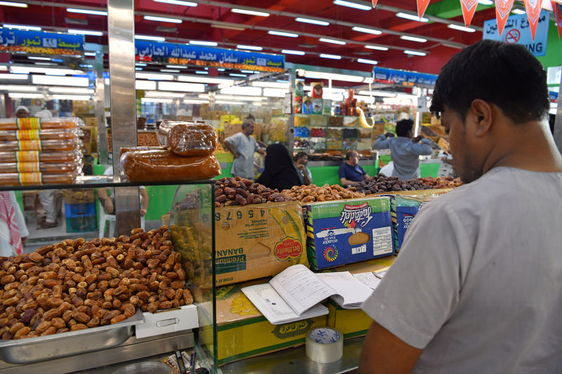 © Reuters. A worker is seen behind the dates stands in a food and dates market in Mecca