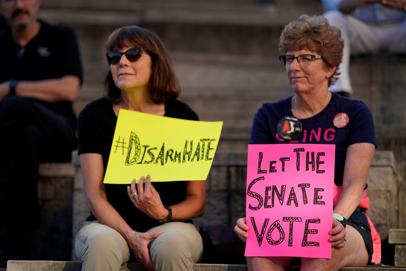 © Reuters. Following the mass shootings in Dayton, Ohio and El Paso, Texas, attendees hold signs at a rally against gun violence, in Louisville