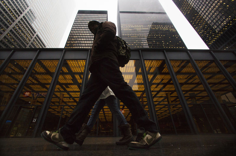 © Reuters. A man walks in front of buildings in the financial district in Toronto