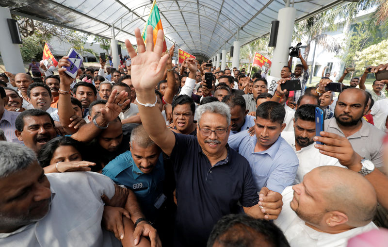 © Reuters. FILE PHOTO: Sri Lanka's former defense secretary Rajapaksa gestures at his supporters after he returned from United States of America in Katunayake