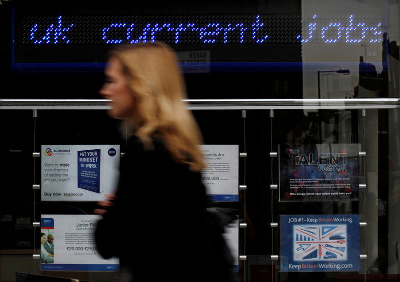 © Reuters. FILE PHOTO: A pedestrian walks past an employment centre in London