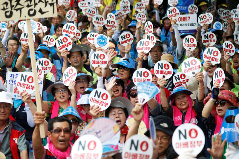 © Reuters. Members of a conservative civic group chant slogans during an anti-Japan protest in Seoul