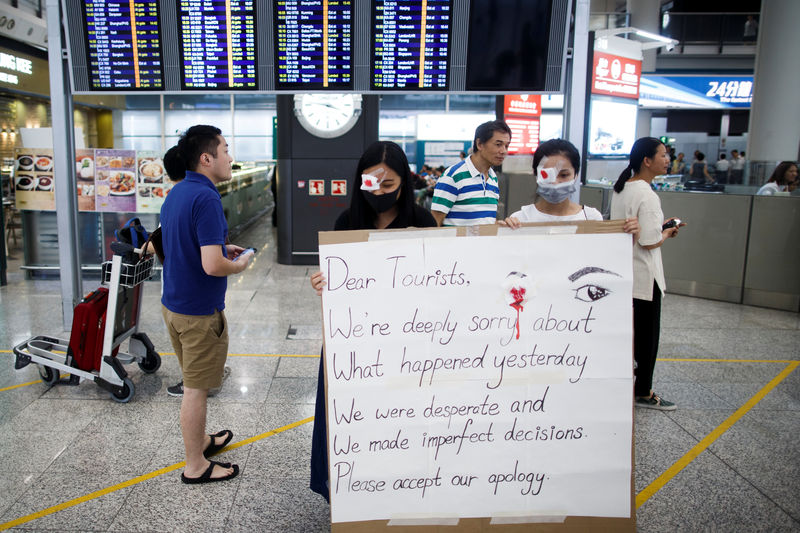 © Reuters. Anti-government demonstrators apologize for yesterday's clashes with police at the airport in Hong Kong
