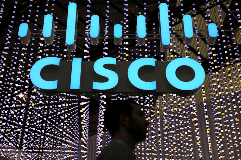 © Reuters. FILE PHOTO: A man passes under a Cisco logo at the Mobile World Congress in Barcelona