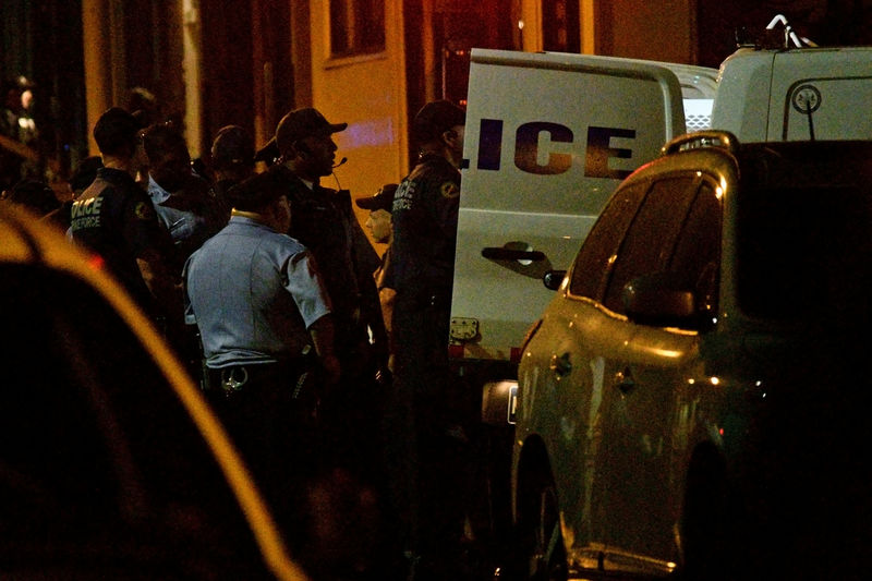 © Reuters. Police officers and vehicles are seen after a suspect (not pictured) in an active shooter situation, where Philadelphia police officers were shot during a drug raid on a home, surrendered in Philadelphia