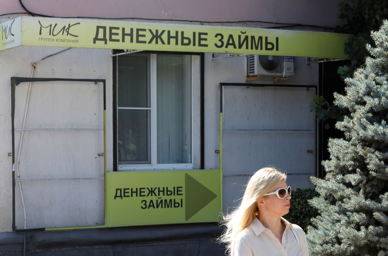 © Reuters. A woman walks past an office of a local lending agency in Stavropol