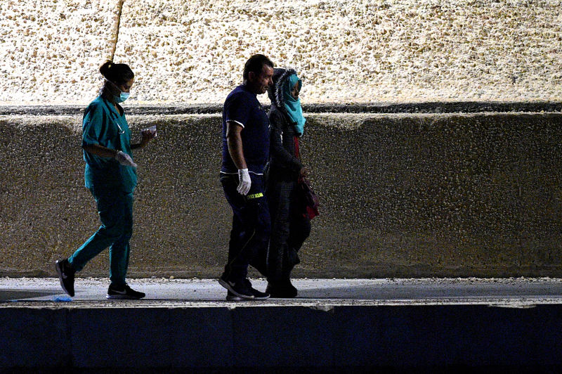 © Reuters. Sick migrants are transferred from the Spanish rescue ship Open Arms to the island of Lampedusa