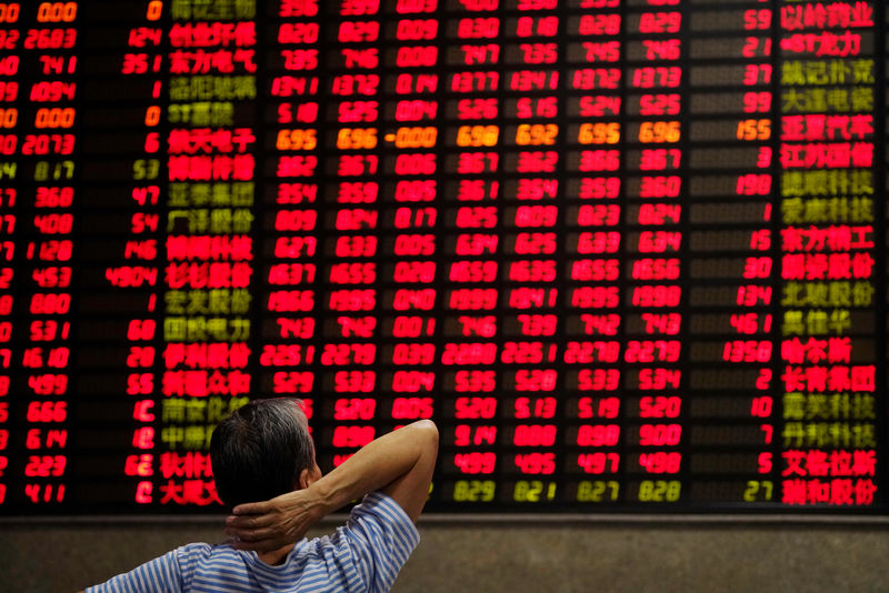 © Reuters. An investor looks at an electronic board showing stock information at a brokerage house in Shanghai