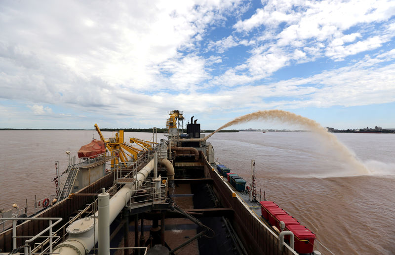 © Reuters. FILE PHOTO: A dredging boat sprays sand at the shore on the Parana river near Rosario, Argentina