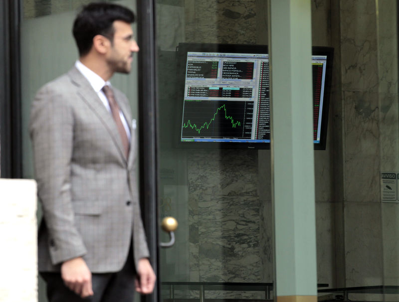 © Reuters. Un uomo cammina accanto all'edificio che ospita la Borsa di Milano