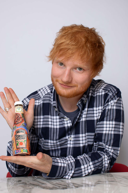 © Reuters. Ed Sheeran poses with a bottle of Heinz Tomato Ketchup in London