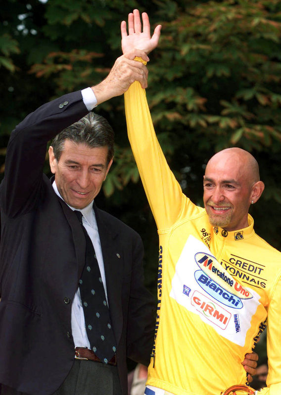 © Reuters. FILE PHOTO: Tour de France winner Marco Pantani of Italy gets his arm raised by the last Italian to win the Tour de France, Felice Gimondi