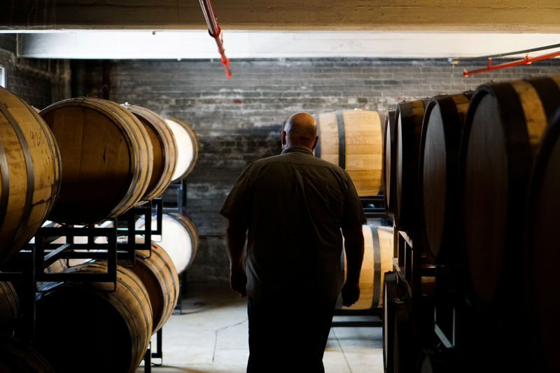 © Reuters. Herman Mihalich walks between barrels of his rye whisky in his distillery in Bristol Pennsylvania