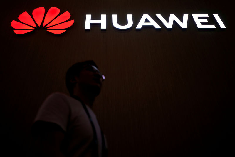 © Reuters. FILE PHOTO: A man walks past a sign board of Huawei at CES (Consumer Electronics Show) Asia 2018 in Shanghai