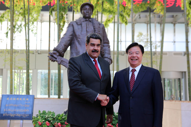© Reuters. FILE PHOTO: Chairman of the Board of China National Petroleum Corporation Wang Yilin and Venezuela's President Nicolas Maduro shake hands during their meeting in Beijing