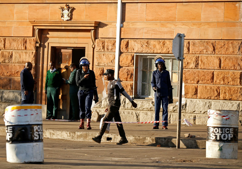 © Reuters. Riot police officers keep watch outside the Tredgold Building Magistrate court in Bulawayo