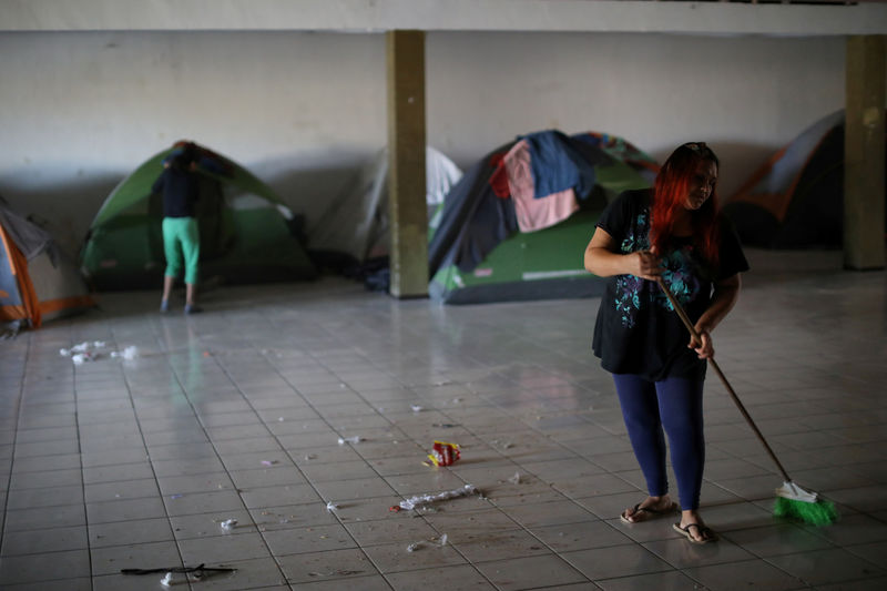 © Reuters. FILE PHOTO: Antonia Portillo Cruz sweeps the floor as part of her duties at Embajadores de Jesus (Ambassadors of Jesus) church and shelter in Tijuana