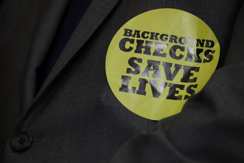 © Reuters. A member of Congress wears a "Background Checks Save Lives" sticker at news conference to introduce gun control legislation on Capitol Hill in Washington
