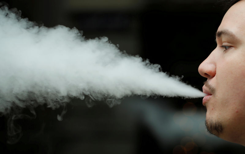 © Reuters. FILE PHOTO: An employee demonstrates vaping at the Dampfi e-cigarette store in Zurich