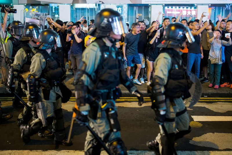 © Reuters. FILE PHOTO: Locals shout at riot police as they chase anti-government protesters down Nathan Road in Mong Kok in Hong Kong