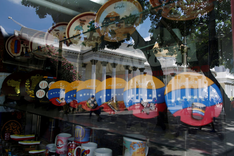 © Reuters. National Assembly building is reflected in a window of a store in Caracas